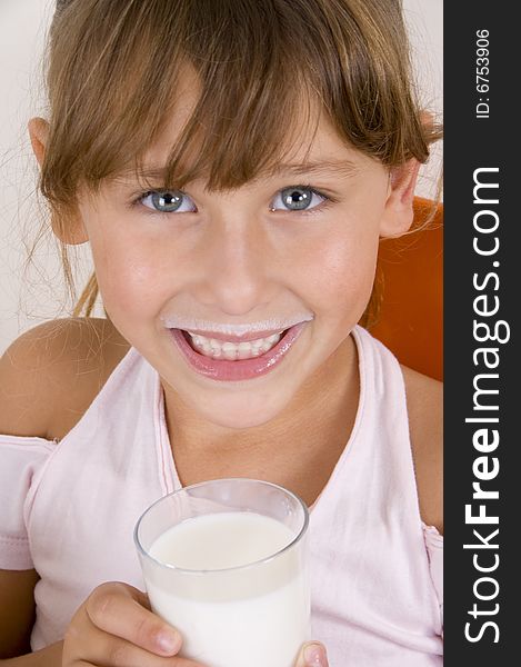 Smiling girl with glass of milk looking at the camera