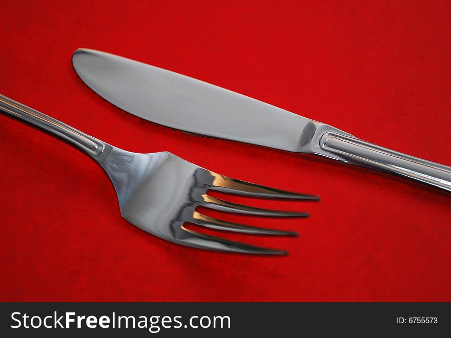 Knife and fork with a red background. Knife and fork with a red background