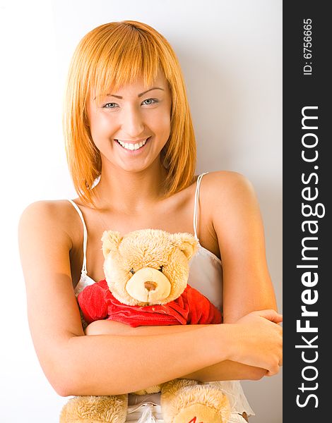 Young woman hugging teddy bear. She's smiing and looking at camera. Front view. Young woman hugging teddy bear. She's smiing and looking at camera. Front view.