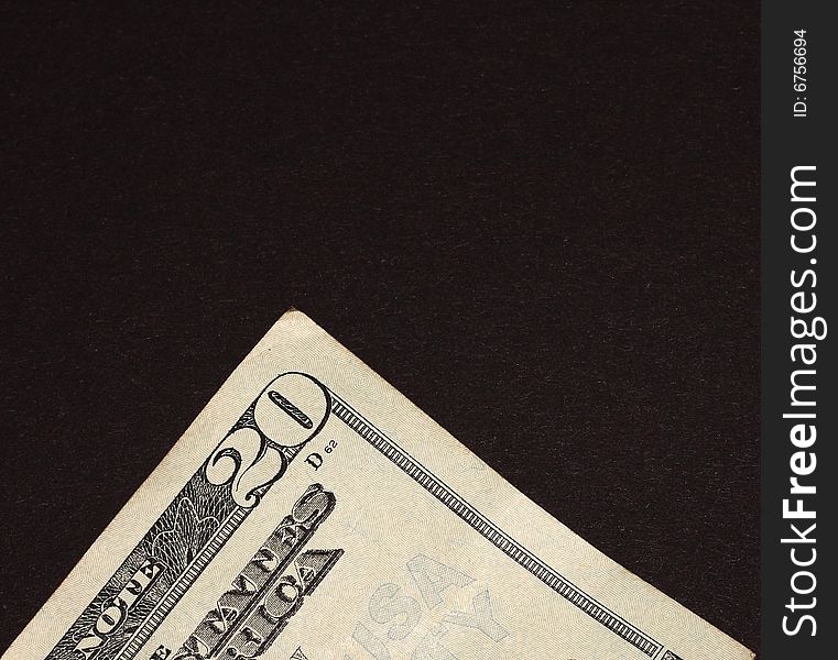 The corner of a twenty dollar bill on a black background. The corner of a twenty dollar bill on a black background.