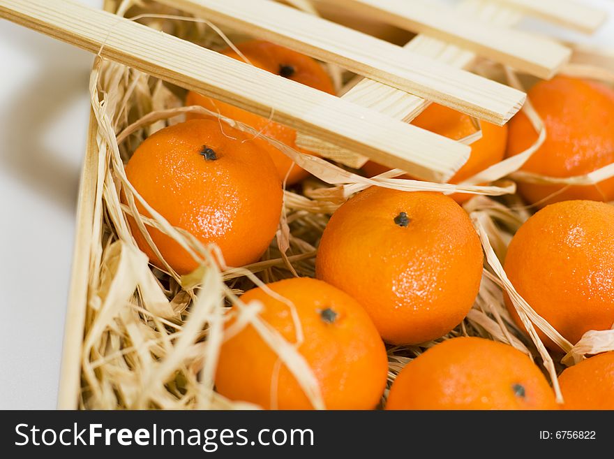 Tangerines with straw in wooden box