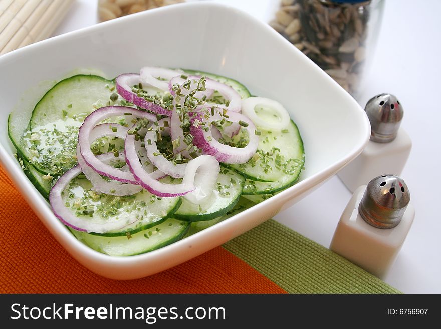 A fresh salad of cucumbers with some red onions