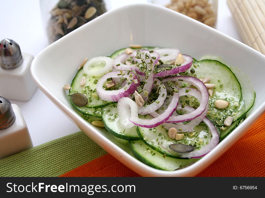 A fresh salad of cucumbers with some red onions
