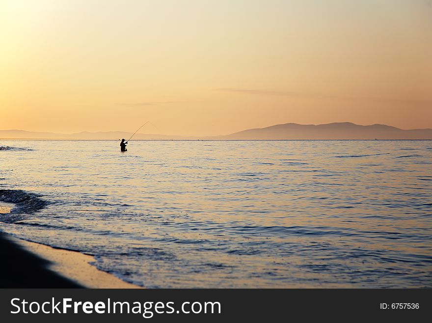 Fisherman silhouette at sunrise, Tuscany, Italy