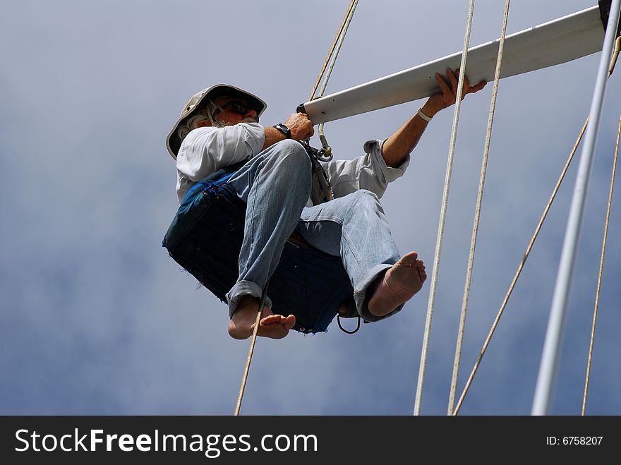 Senior man, marine surveyor, inspecting spreader on sailboat. Senior man, marine surveyor, inspecting spreader on sailboat.