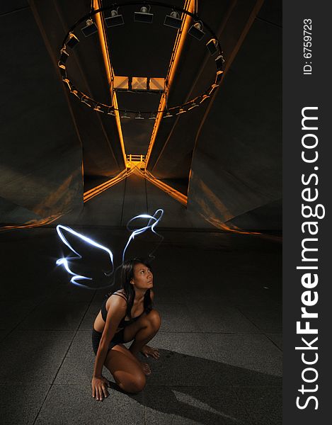 Artistic Picture of a Dancer standing under athletic equipment, painted with light to look like angle wings and halo. Artistic Picture of a Dancer standing under athletic equipment, painted with light to look like angle wings and halo.