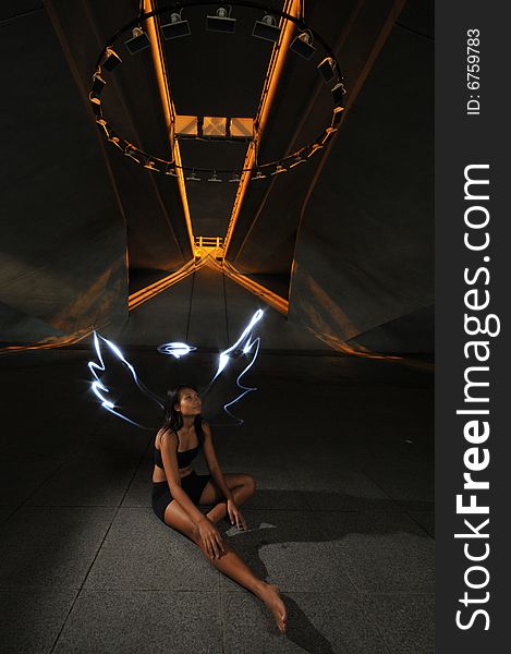 Artistic Picture of a Dancer standing under athletic equipment, painted with light to look like angle wings and halo. Artistic Picture of a Dancer standing under athletic equipment, painted with light to look like angle wings and halo.