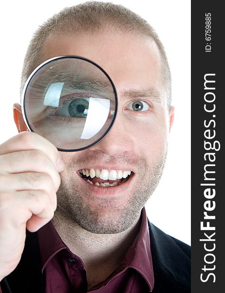 Businessman in a suit looks through a magnifying glass