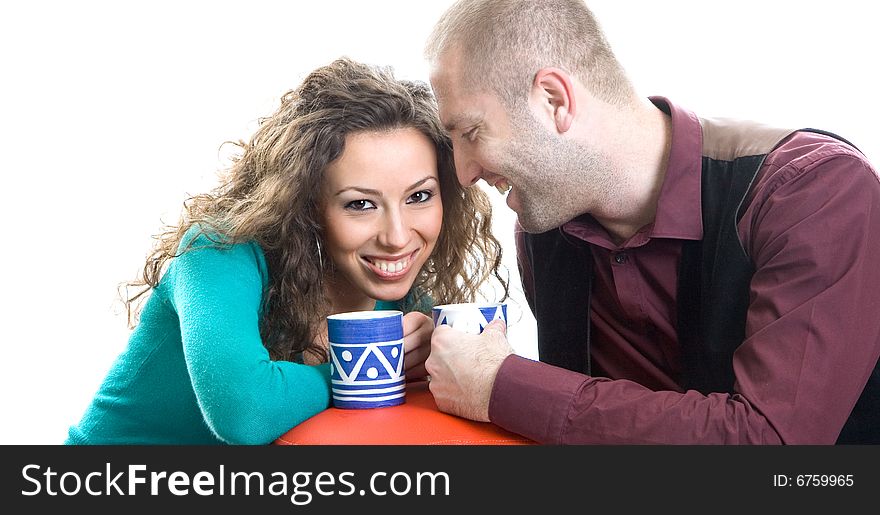 Attractive coupler at home with coffee cups and smiling at each other