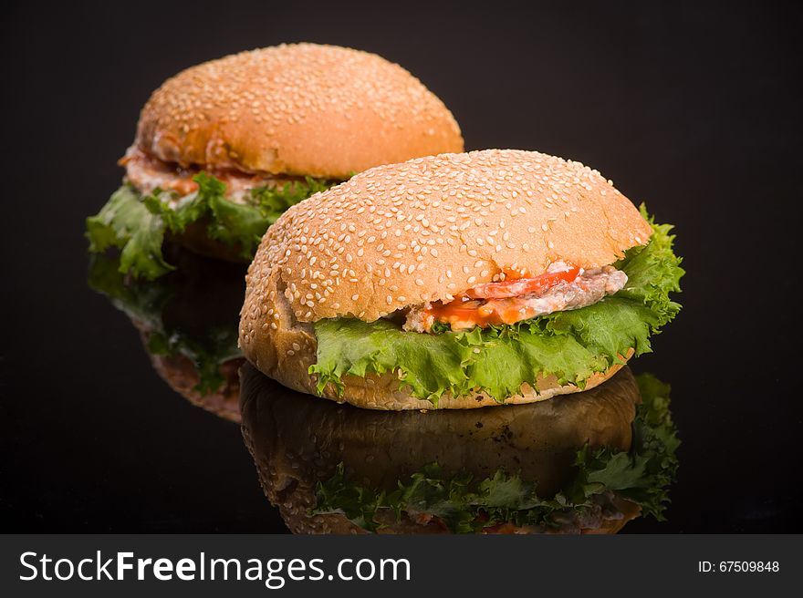 Two delicious hamburger with reflection on the table. Two delicious hamburger with reflection on the table.