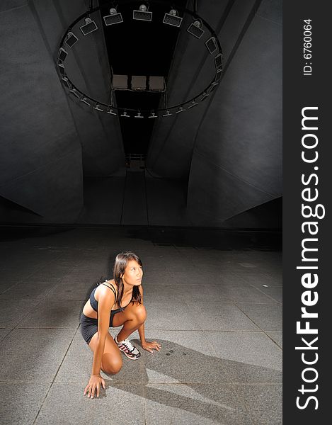 Athletic woman on cement floor underground. Athletic woman on cement floor underground.