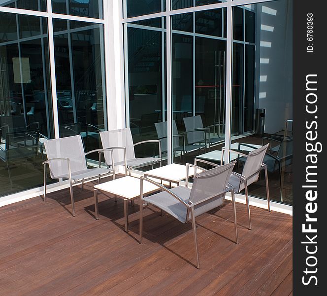 Open bar on wooden floor with white chairs