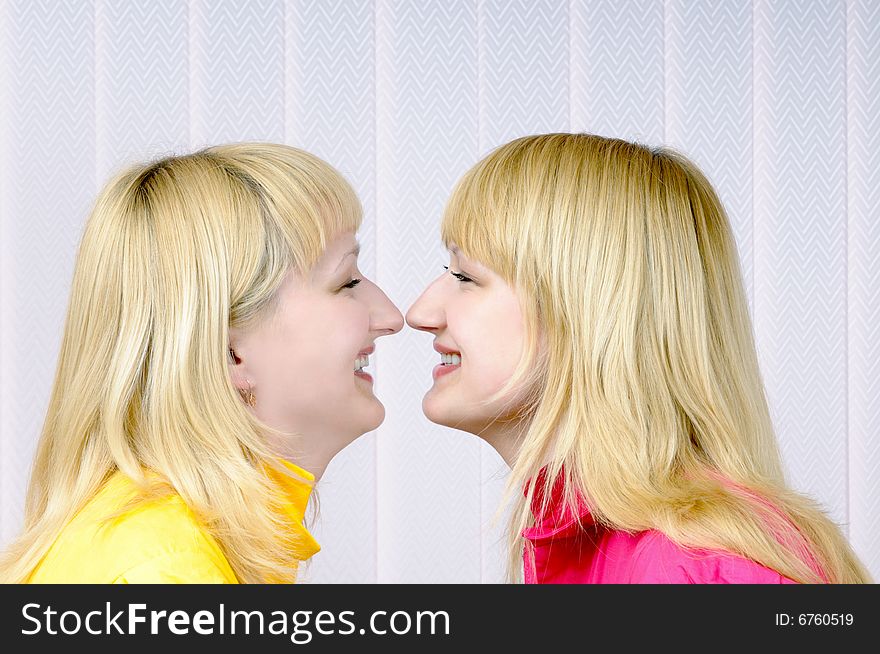 Two beautiful blond girls nose to nose