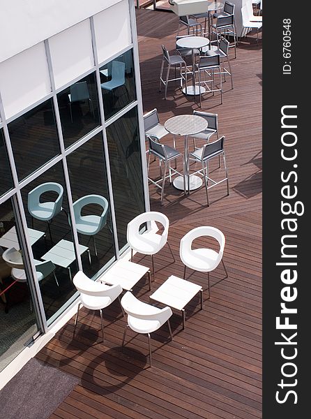 Open bar on wooden floor with white chairs