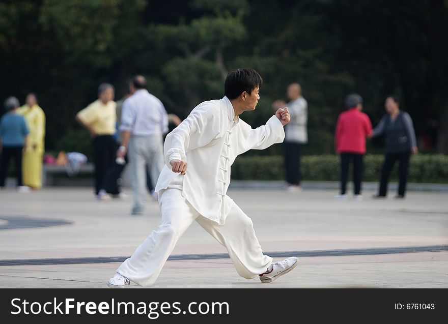 The man play the chinese wushu in a park morning. The man play the chinese wushu in a park morning.