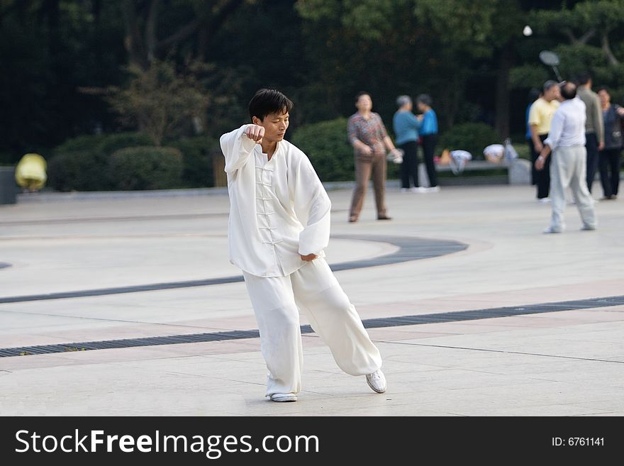 The man play the chinese wushu in a park morning. The man play the chinese wushu in a park morning.