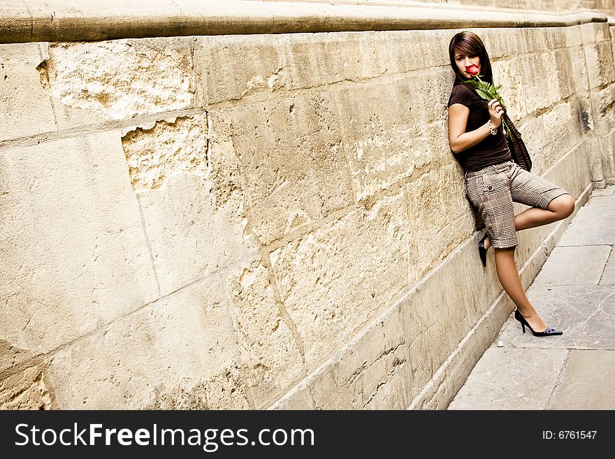Elegant woman in old wall with a rose on her hands. Elegant woman in old wall with a rose on her hands.
