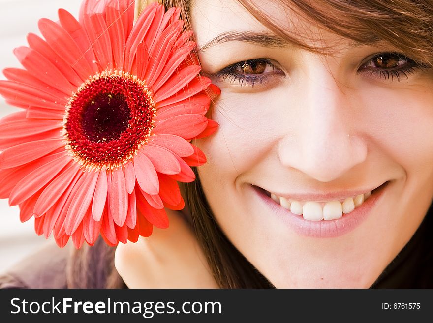 Young smiling woman with huge red flower. Young smiling woman with huge red flower.