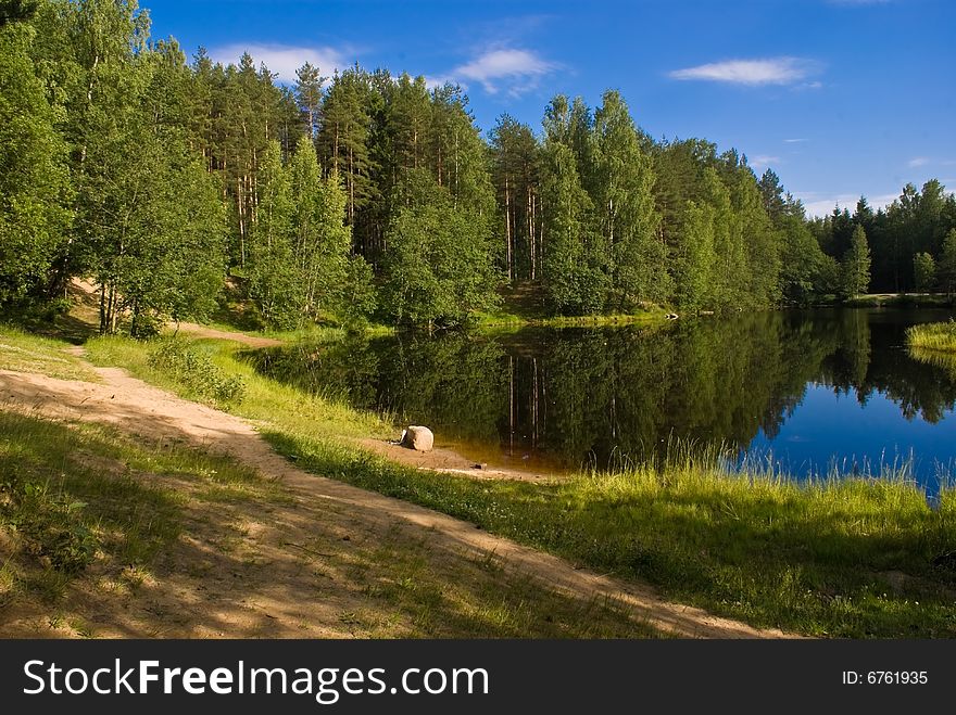 A far pond in the forest with sand bank. A far pond in the forest with sand bank