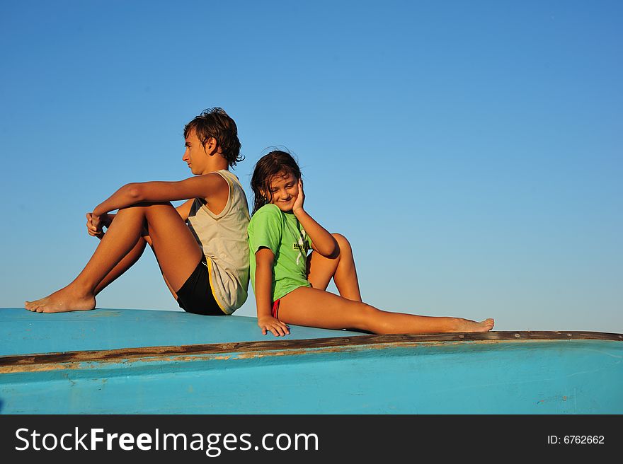 A young boy and a girl relaxing on a boat