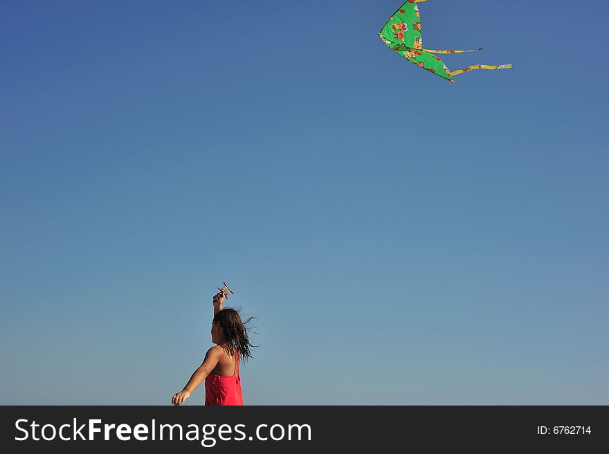 Little girl running and flying a kite. Little girl running and flying a kite