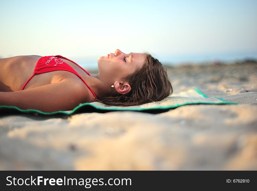 Little girl lying on the beach, close up. Little girl lying on the beach, close up