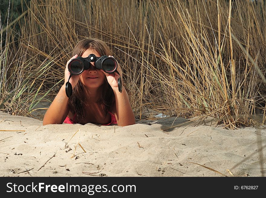 Young girl looking through binocular, low angle view. Young girl looking through binocular, low angle view