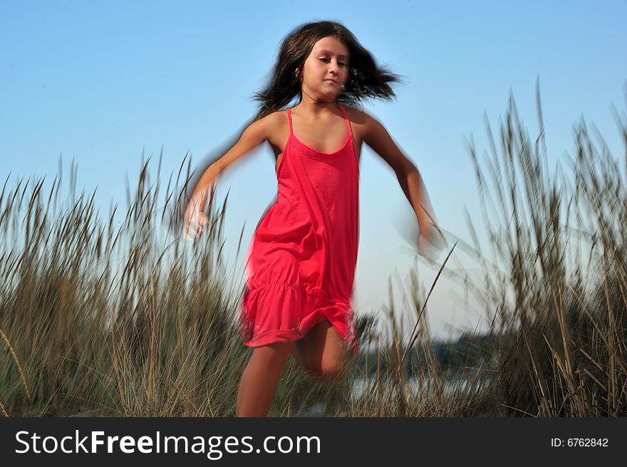 Young girl in red dress running in nature - motion effect. Young girl in red dress running in nature - motion effect