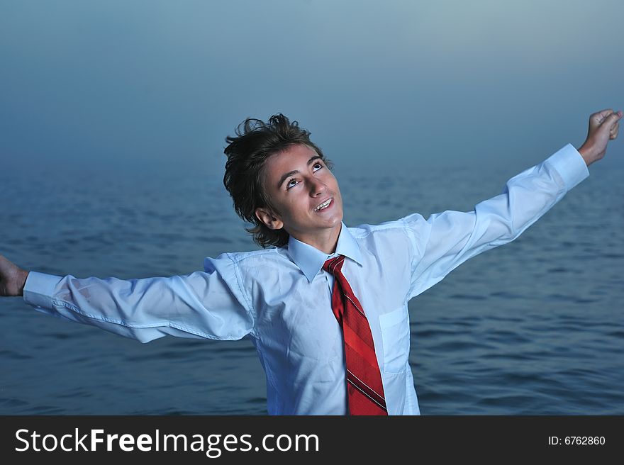 Young businessman standing on sea and looking up. Young businessman standing on sea and looking up