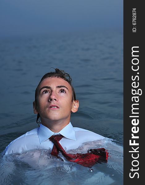 Young businessman standing on sea and looking up. Young businessman standing on sea and looking up