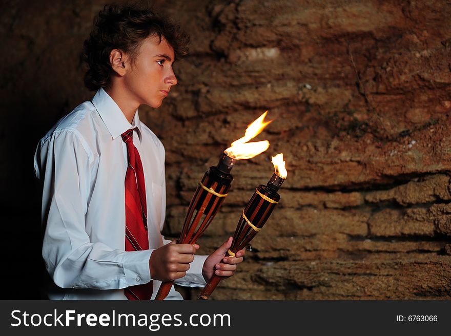 Young businessman lighting with torch in a cave. Young businessman lighting with torch in a cave
