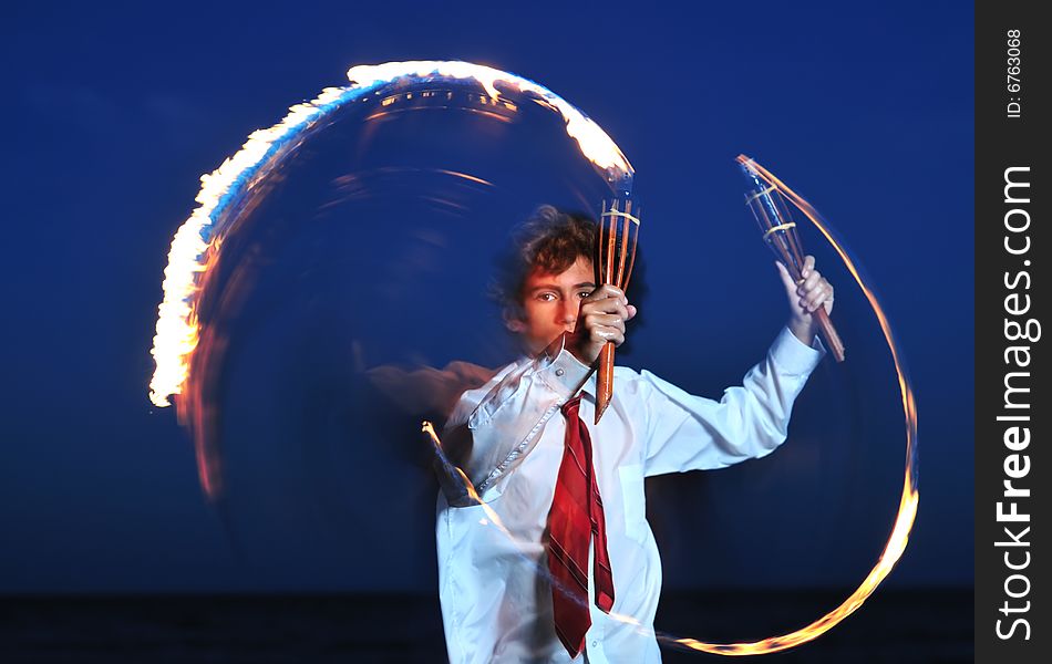 Young businessman handling flaming torch in night. Young businessman handling flaming torch in night