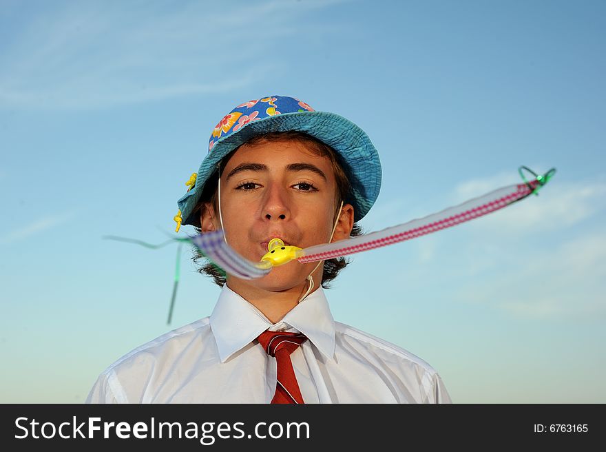 Young boy in shirt and tie blowing in blowers. Young boy in shirt and tie blowing in blowers