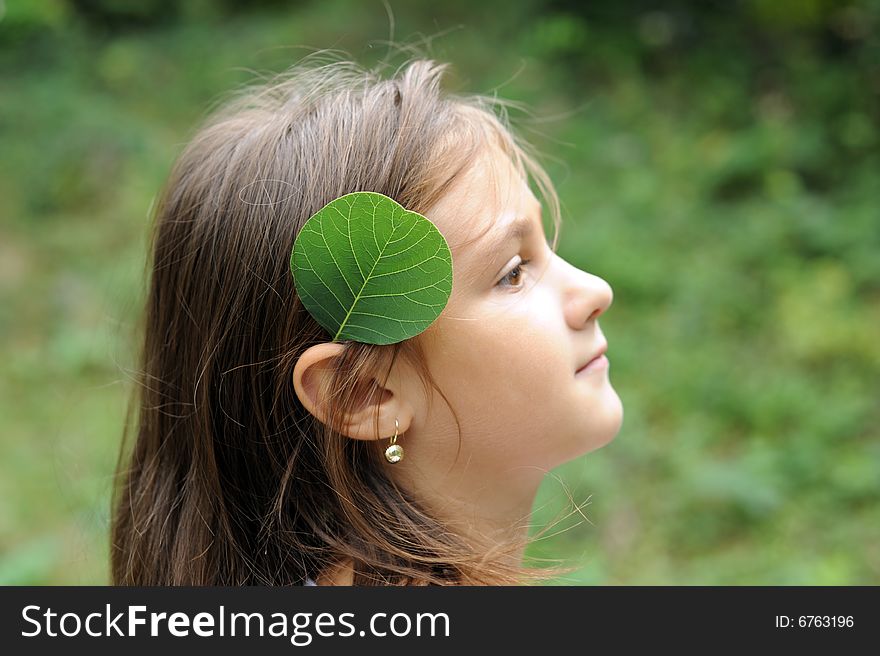 Little girl portrait with a green leaf on ear. Little girl portrait with a green leaf on ear