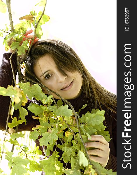 Woman lovingly holding leaves on a tree. Woman lovingly holding leaves on a tree.