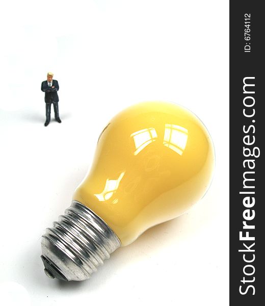 A businessman standing behind a lightbulb. A businessman standing behind a lightbulb