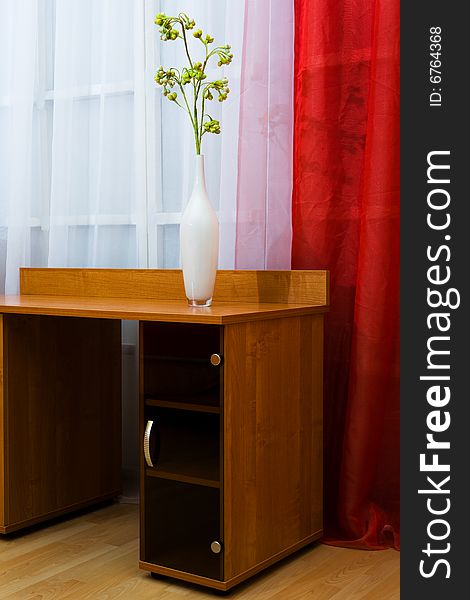 Dry flower in a vase on a background of curtains