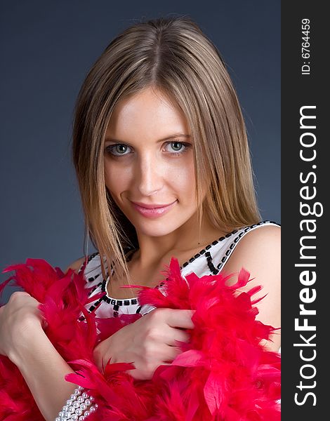 Portrait of the beautiful girl with red feathers