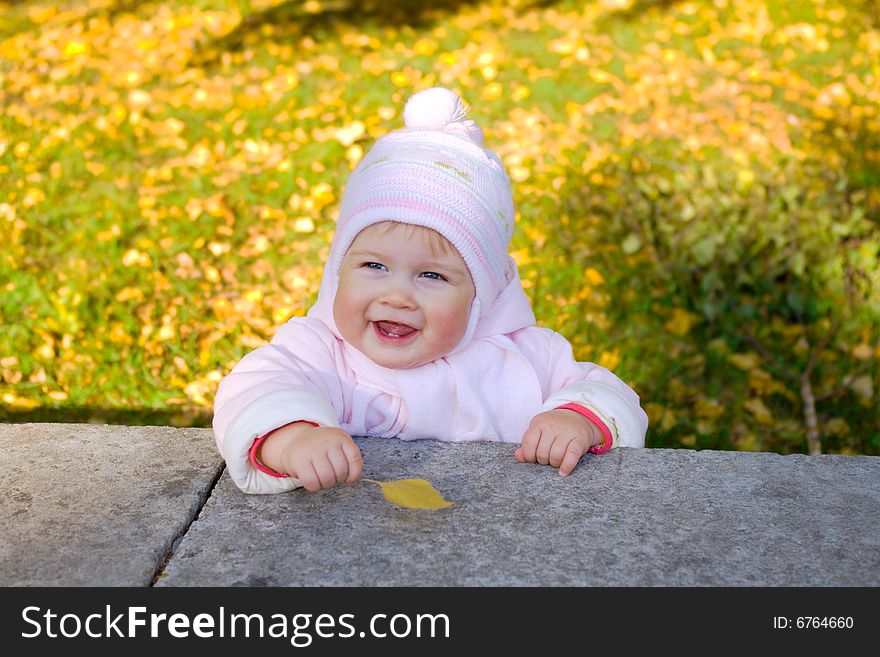 Small smiling baby with yellow leaf