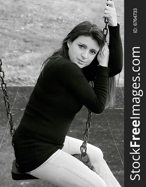 Black and white image of pretty young female on a swing. Black and white image of pretty young female on a swing