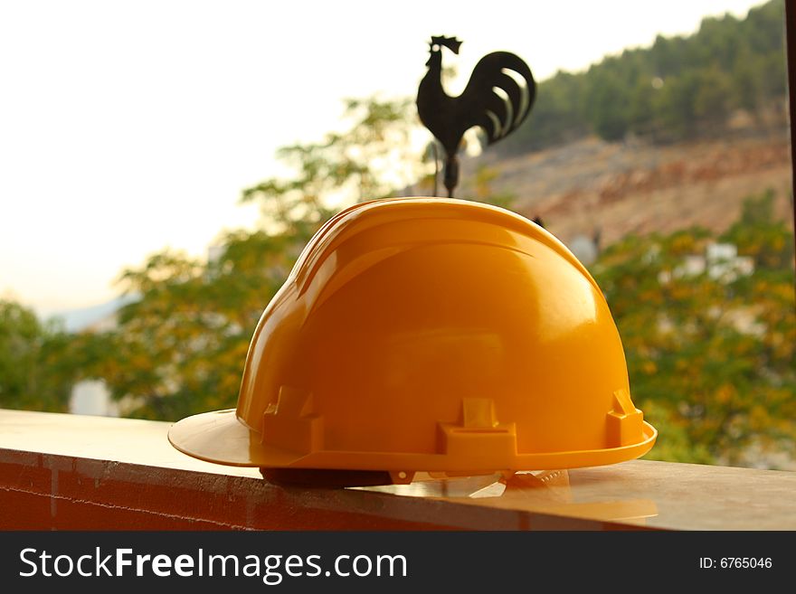 On the brick wall is working yellow helmet. On the brick wall is working yellow helmet