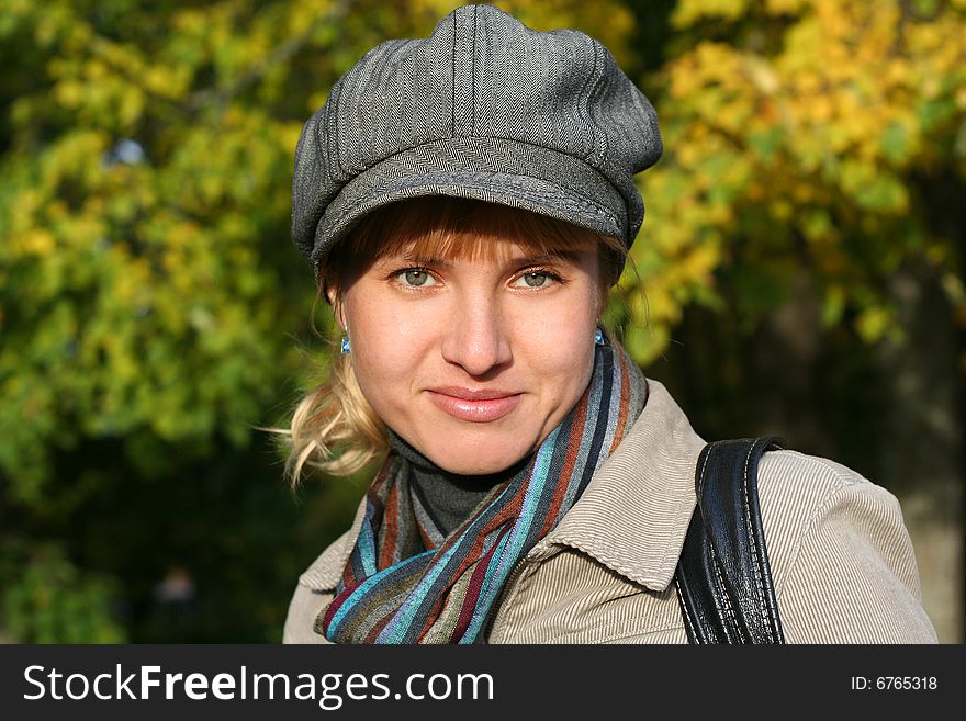 Beautiful blond  young woman in cap in autumn park. Beautiful blond  young woman in cap in autumn park