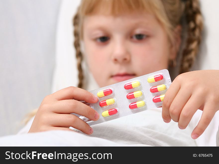 An image of a girl with pills in her hands