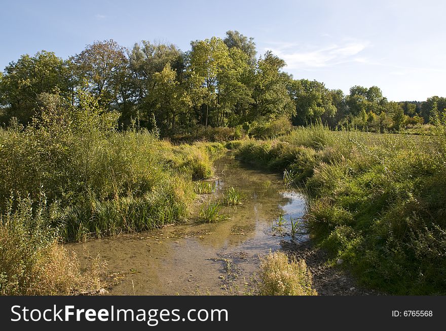 Typical landscape west of munich with meadows and creek in the light of late summer or beginning autumn. Typical landscape west of munich with meadows and creek in the light of late summer or beginning autumn