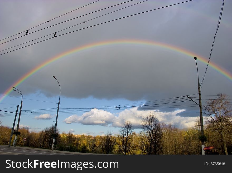 The cloudy sky and autumn rainbow above forest. The cloudy sky and autumn rainbow above forest.