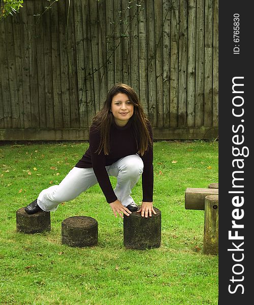 Woman climbing over stepping stones in the playground. Woman climbing over stepping stones in the playground.