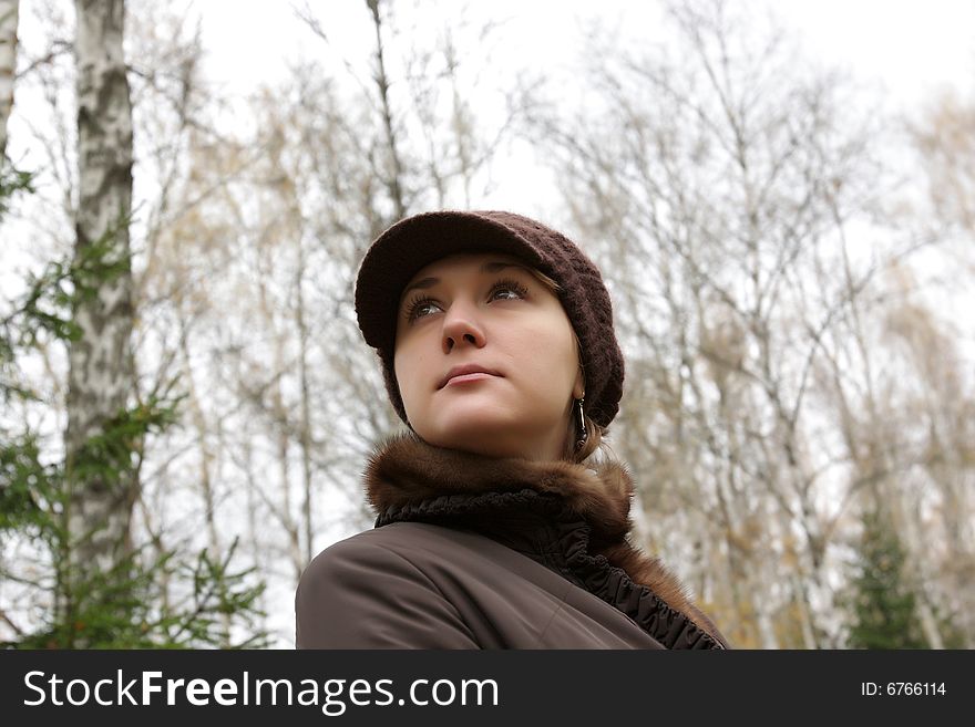 Autumnal portrait of young woman on trees background