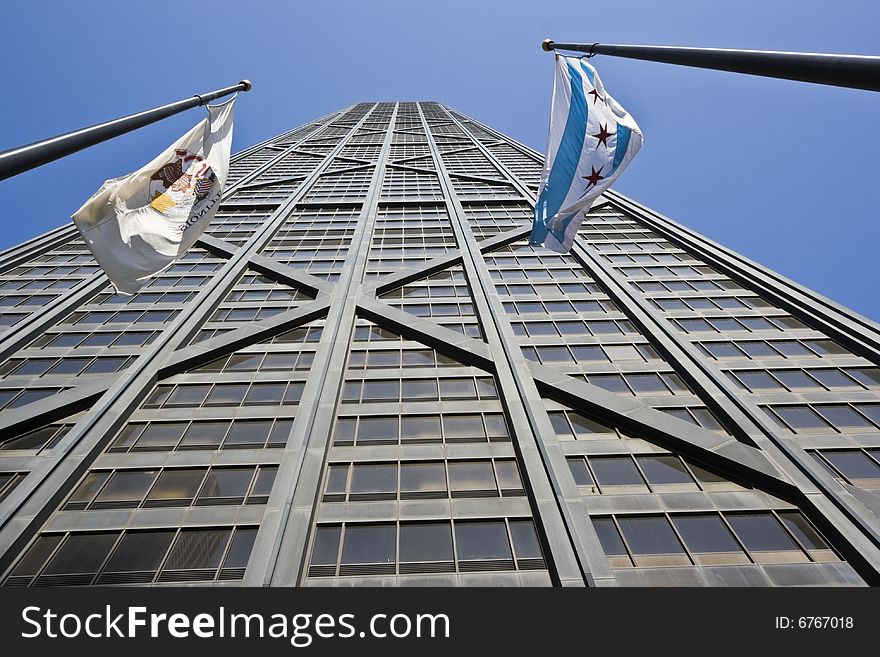 Hancock Tower and waving flags of Illinois and Chicago.