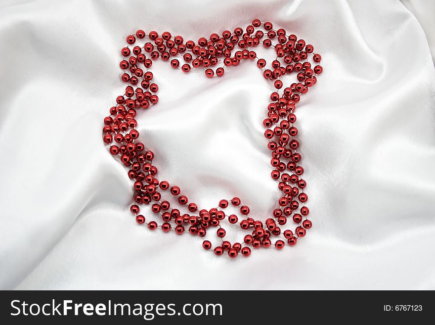 Red beads on white silk