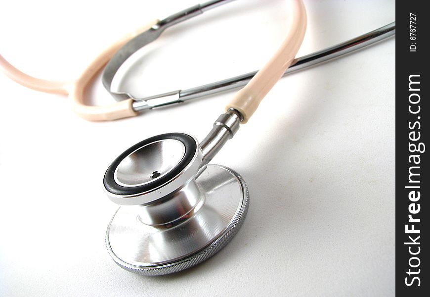 Close-up of a pink stethoscope on a white background